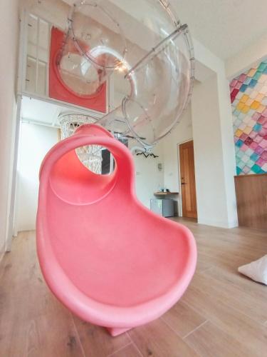 a pink chair in a room with a chandelier at 杉灣小徑民宿 in Xiaoliuqiu