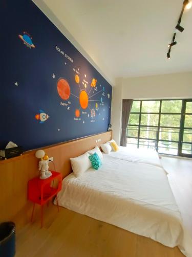 a bedroom with a large bed with a blue wall at 杉灣小徑民宿 in Xiaoliuqiu