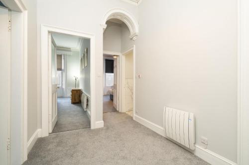 a hallway with white walls and an arched doorway at Lochside Apartments, Apt B in Montrose