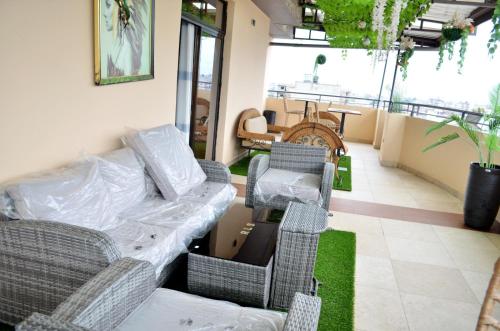 a room with chairs and a table and a couch at Résidence Le Sommet Douala in Douala