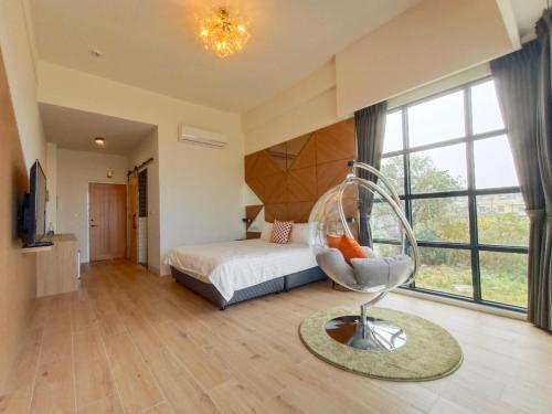 a bedroom with a bed and a chair in a room at 杉灣小徑民宿 in Xiaoliuqiu