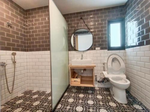 a bathroom with a toilet and a sink and a mirror at 杉灣小徑民宿 in Xiaoliuqiu