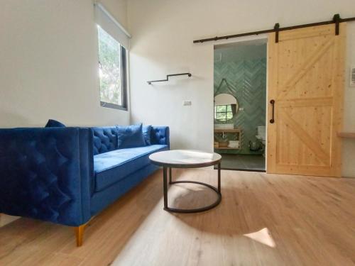 a living room with a blue couch and a table at 杉灣小徑民宿 in Xiaoliuqiu