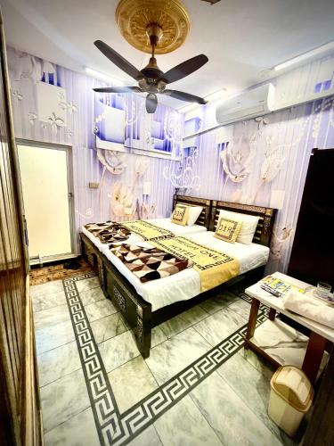 a bedroom with a bed and a ceiling fan at Jhelum One Hotel, Shandar Chowk in Jhelum