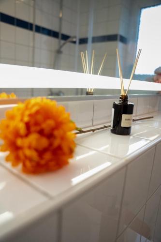 a yellow flower sitting on a counter next to a bottle at Stilvoll Apt - Balkon - Netflix in Saarbrücken
