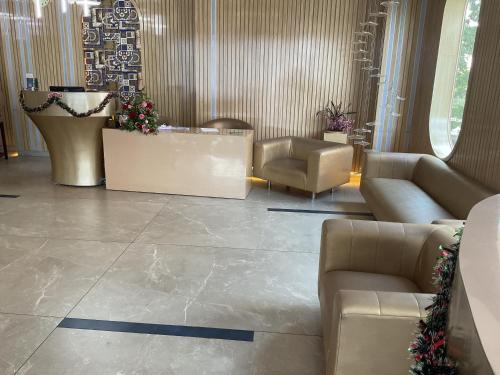a lobby with couches and chairs in a building at Hotel Jagadish International-Sankey Road in Bengaluru