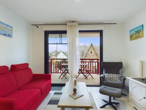 un salon avec un canapé rouge et une table dans l'établissement À 45m de la plage - vue mer - Appart pour 4 avec balcon, à Pléneuf-Val-André