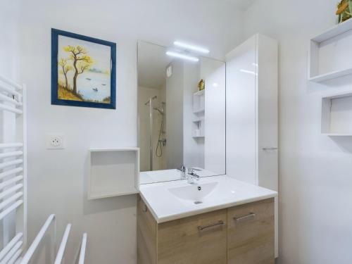 une salle de bain avec un lavabo et un miroir dans l'établissement À 45m de la plage - vue mer - Appart pour 4 avec balcon, à Pléneuf-Val-André