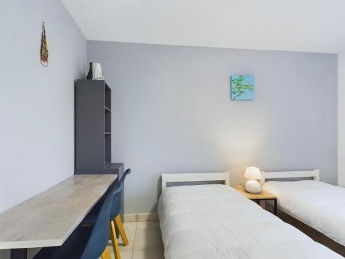 - une chambre avec 2 lits et un bureau dans l'établissement À 45m de la plage - vue mer - Appart pour 4 avec balcon, à Pléneuf-Val-André