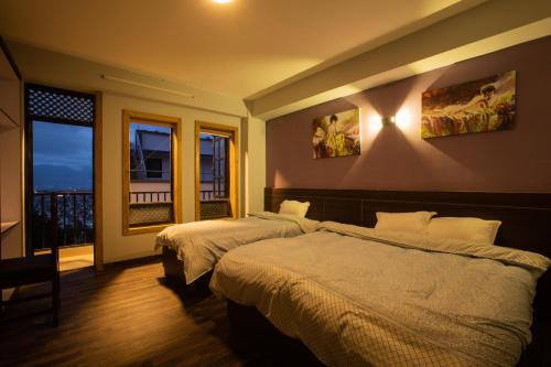 a hotel room with two beds and a balcony at La Dimora Homestay in Kirtipur