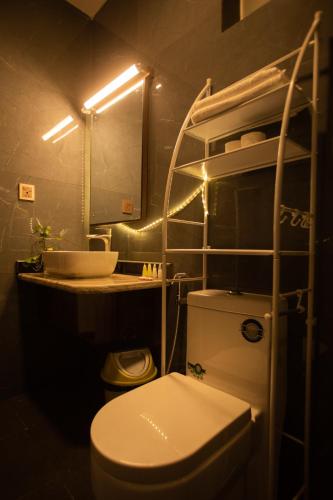 a bathroom with a toilet and a sink and a mirror at La Dimora Homestay in Kirtipur