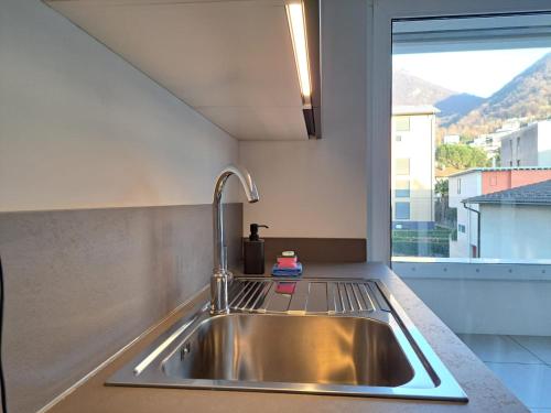 a stainless steel sink in a kitchen with a window at Urban Residence by Quokka 360 - Apartments with parking in Lugano in Aldesago