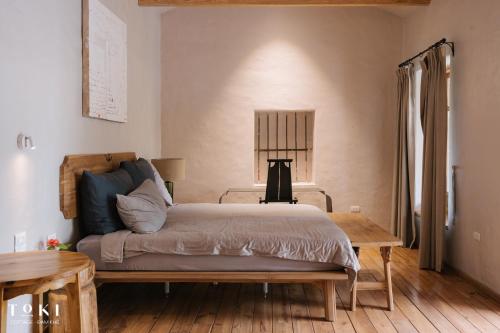 a bedroom with a bed and a wooden floor at TOKI Cottage Đam Khê in Vũ Lâm