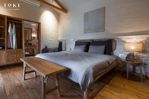 a bedroom with a large bed and a wooden table at TOKI Cottage Đam Khê in Vũ Lâm