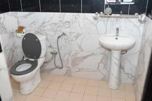 a bathroom with a toilet and a sink at Résidence Le Sommet Douala in Douala
