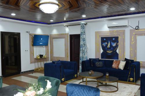 a living room with a blue couch and a table at Résidence Le Sommet Douala in Douala