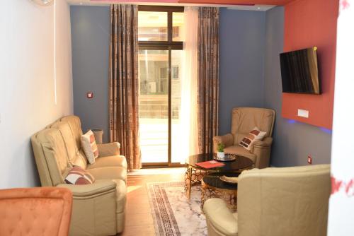 a living room with two chairs and a table at Résidence Le Sommet Douala in Douala