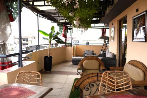 a patio with chairs and tables and a couch at Résidence Le Sommet Douala in Douala