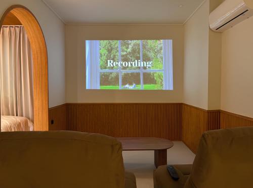 a room with a window with the word recoting at lyrical Hotel Busan Yeongdo in Busan