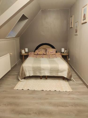 une chambre avec un grand lit dans un grenier dans l'établissement Maison de ville, à Bourbourg