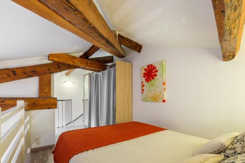 - une chambre avec un lit et des poutres apparentes dans l'établissement Jolie duplex avec patio, à Nice