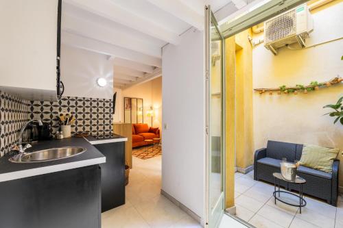 une cuisine avec un évier et un salon dans l'établissement Jolie duplex avec patio, à Nice