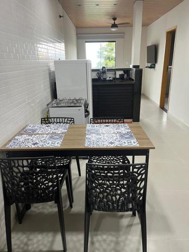 a kitchen with a table and two chairs and a stove at Moradas de Ibicuí - Apartamentos com vista para o mar in Mangaratiba