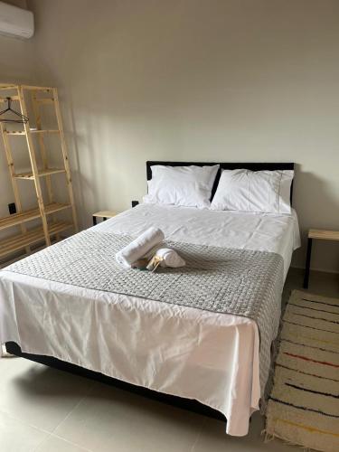 a large white bed with a towel on it at Moradas de Ibicuí - Apartamentos com vista para o mar in Mangaratiba