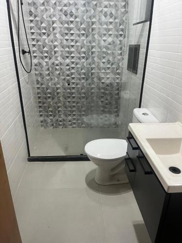a bathroom with a shower and a toilet and a sink at Moradas de Ibicuí - Apartamentos com vista para o mar in Mangaratiba