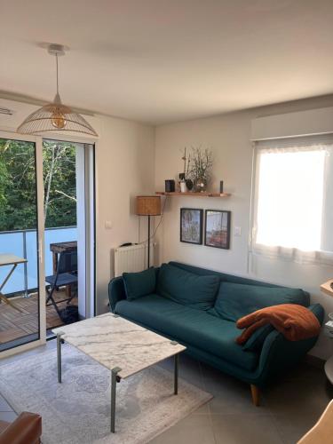 un salon avec un canapé vert et une table dans l'établissement Men Konk, à Concarneau