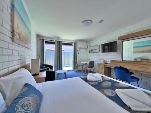 a bedroom with a bed and a living room at Albury Garden Court Motel in Albury