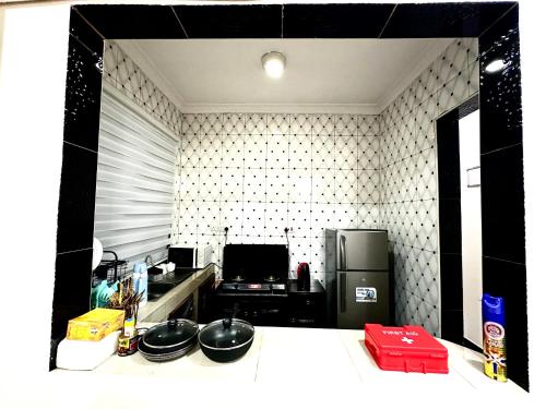 a kitchen with a counter with bowls and a refrigerator at Casazuri Homestay in Dar es Salaam