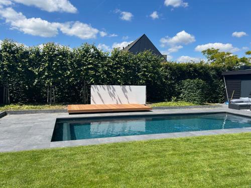 a swimming pool in a yard with a lawn at Slaapplaatsen 2-4 personen voor bezoek DTRH in Beuningen
