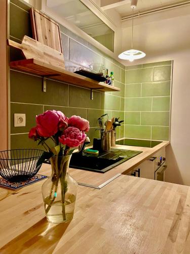 un vase de roses assis sur une table dans une cuisine dans l'établissement Gite La Merlandie, à Montazeau