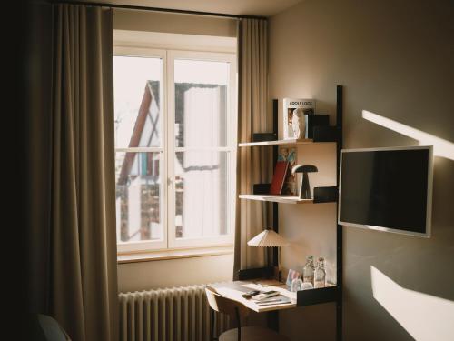 a room with a desk in front of a window at Landgasthof Riehen Hotel and Restaurant, Basel in Basel