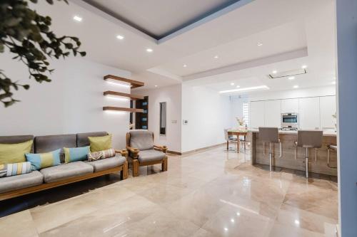 a living room with a couch and a table at Dolmen Court Qawra fl13 w shared pool! by Homely in St. Paul's Bay