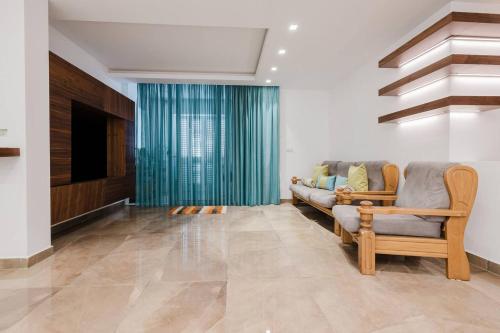 a living room with a couch and a television at Dolmen Court Qawra fl13 w shared pool! by Homely in St. Paul's Bay