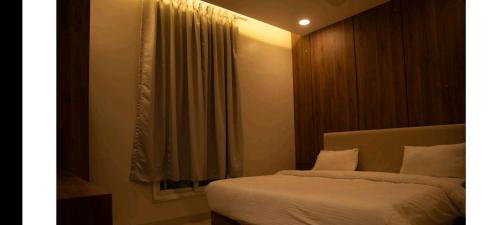 a bedroom with a bed and a window at RadhaKrishna Executive in Tuljapur