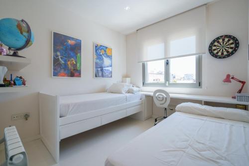 Un dormitorio blanco con dos camas y una ventana. en Torre Blanca, en Palma de Mallorca