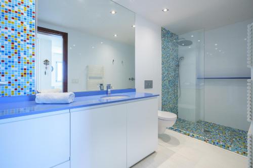 Un baño con lavabo, inodoro y espejo. en Torre Blanca, en Palma de Mallorca