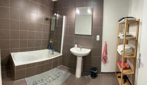 La salle de bains est pourvue d'un lavabo, de toilettes, d'une baignoire et d'un miroir. dans l'établissement Bobby, à Besançon