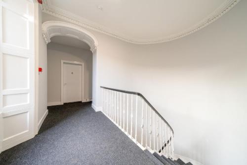 a staircase with white walls and a white stair case at Lochside Apartments, Apt C in Montrose