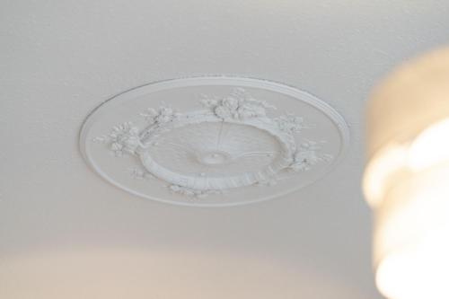 a ceiling with a white plate with flowers on it at Lochside Apartments, Apt C in Montrose