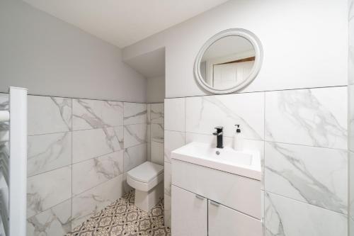 a white bathroom with a sink and a mirror at Lochside Apartments, Apt C in Montrose