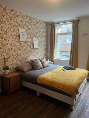 une chambre avec un lit et une fenêtre dans l'établissement In The Air cosy room (Cœur Historique de Liège), à Liège