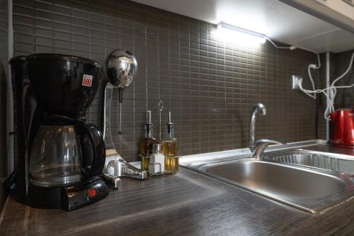 a kitchen counter with a coffee maker next to a sink at Tranquil Getaway by InFox Suites in Afitos