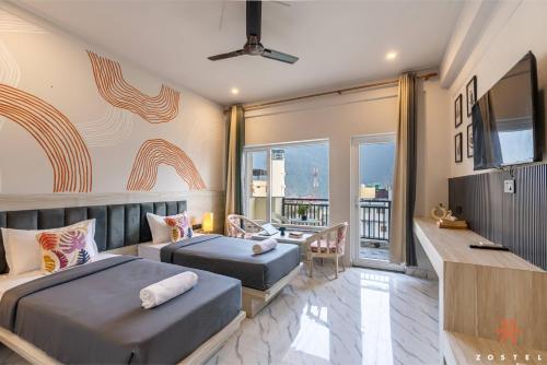 a bedroom with two beds and a flat screen tv at Zostel Rishikesh, Tapovan in Rishīkesh