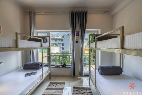 two bunk beds in a room with a window at Zostel Rishikesh, Tapovan in Rishīkesh