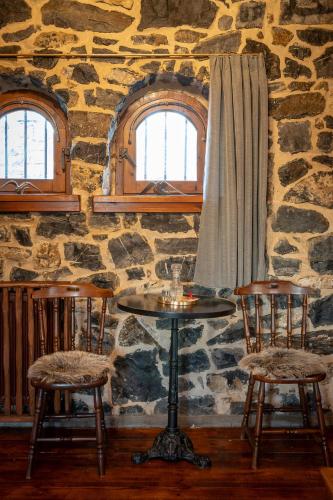a stone room with a table and two chairs at 4 Seasons Premium Chalet & Massage Treatments in Palaios Agios Athanasios