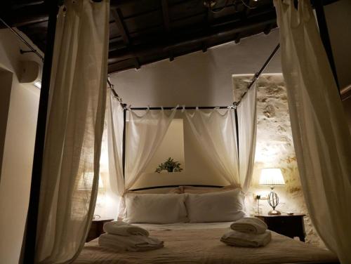 a bedroom with a canopy bed with towels on it at Christina's Villa with sea view in Daratso